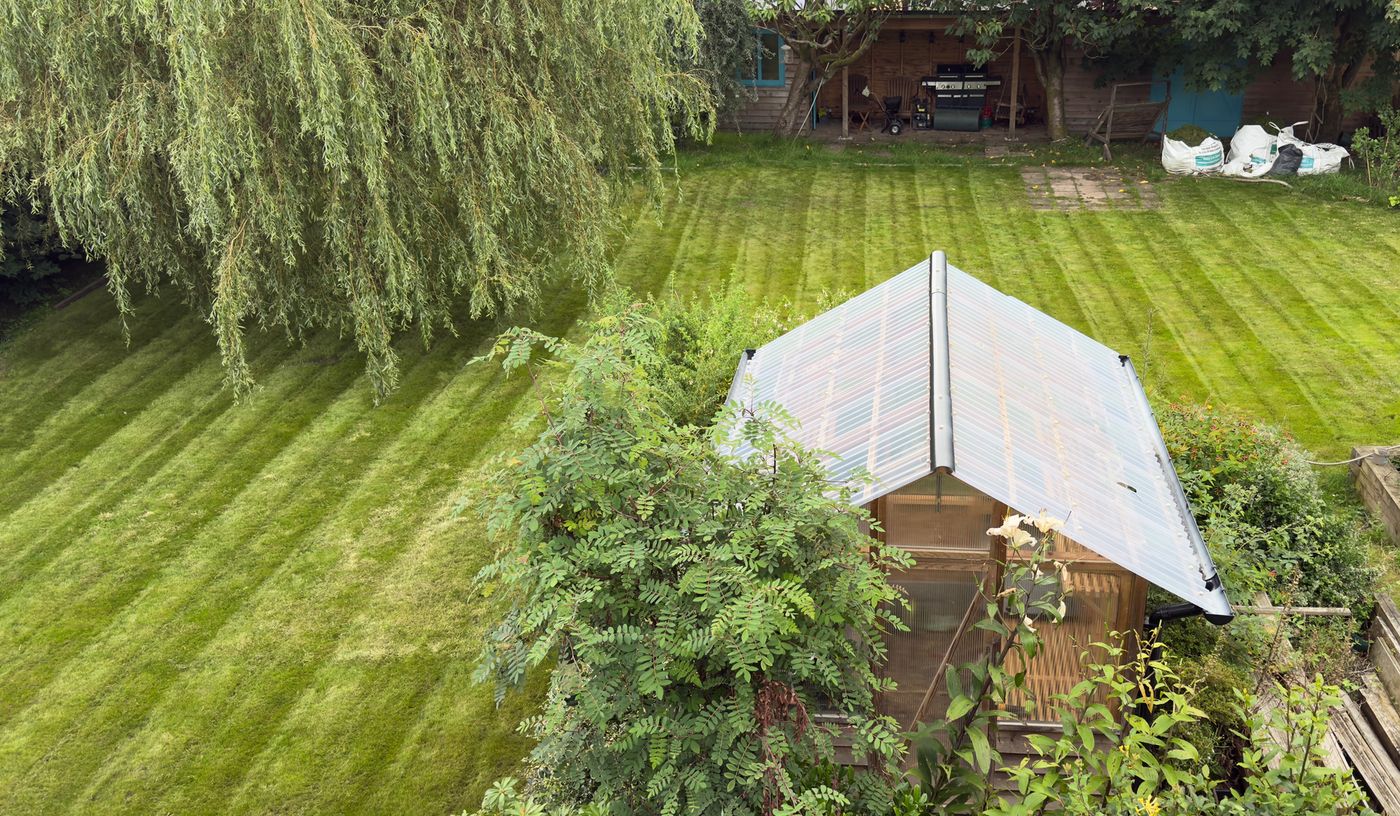 The same garden after restoration, with a striped, freshly mown lawn